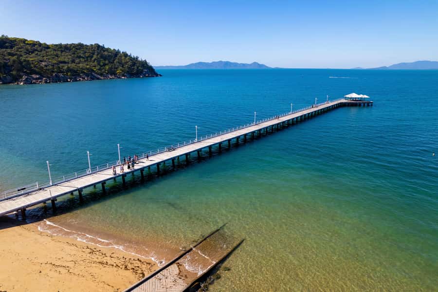 Magnetic Island: Guided Bus Tour with Morning Tea - Cockle Bay and Picnic Bay show two sides of island life